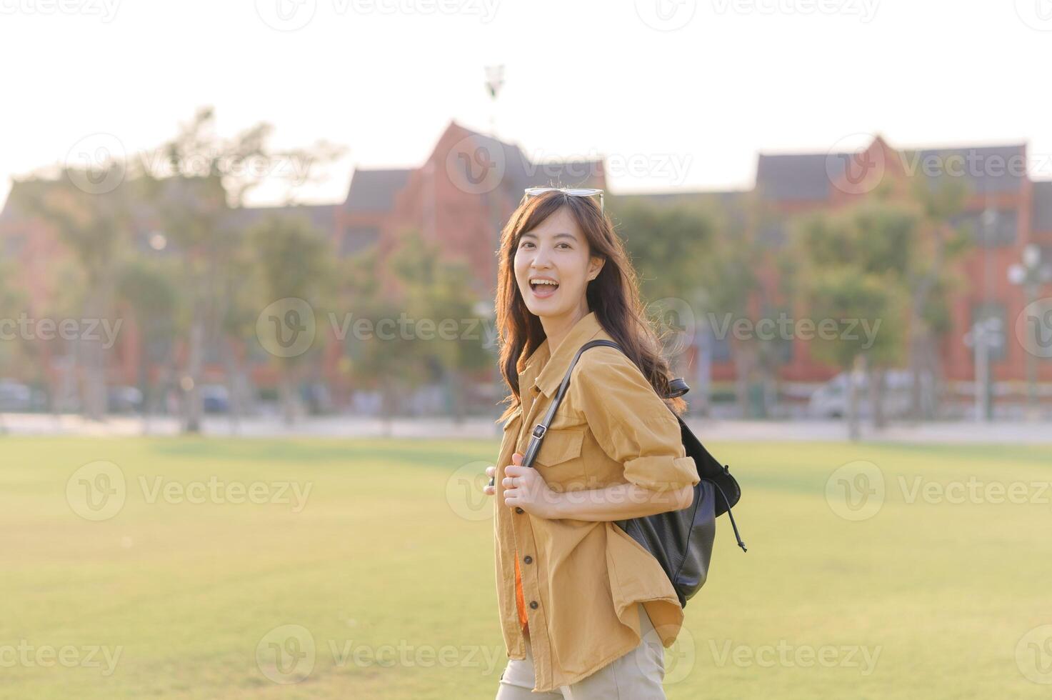 Asian woman walking in the park with backpack photo