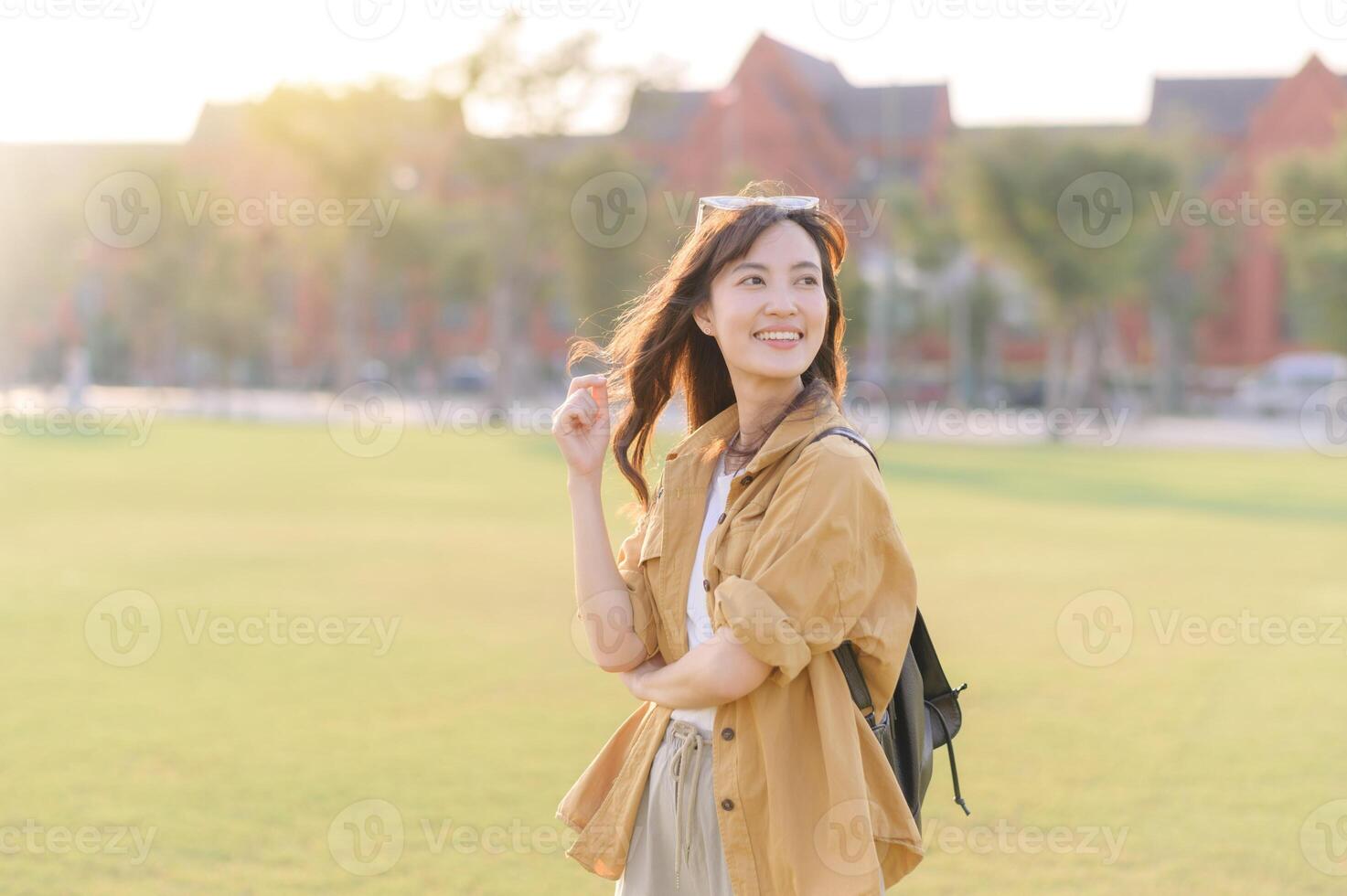 Asian woman in yellow jacket and skirt standing in grass photo