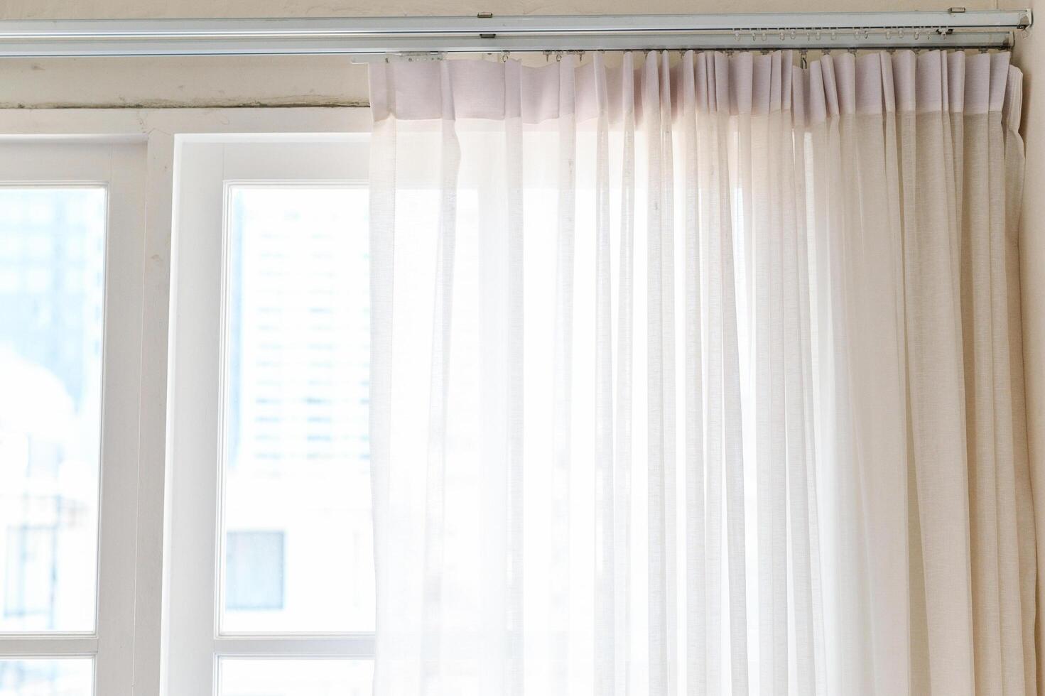 Soft white curtains drape elegantly over window, allowing gentle light to filter through, creating serene atmosphere photo