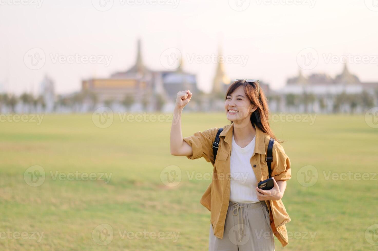 Asian woman in the field holding her camera photo