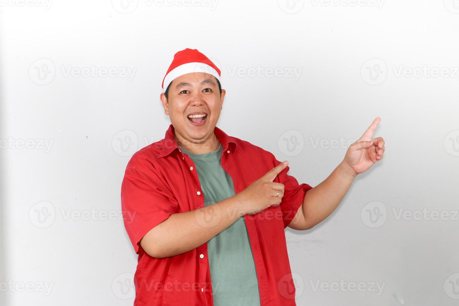 Happy Man in Santa Hat Pointing Finger into empty space photo