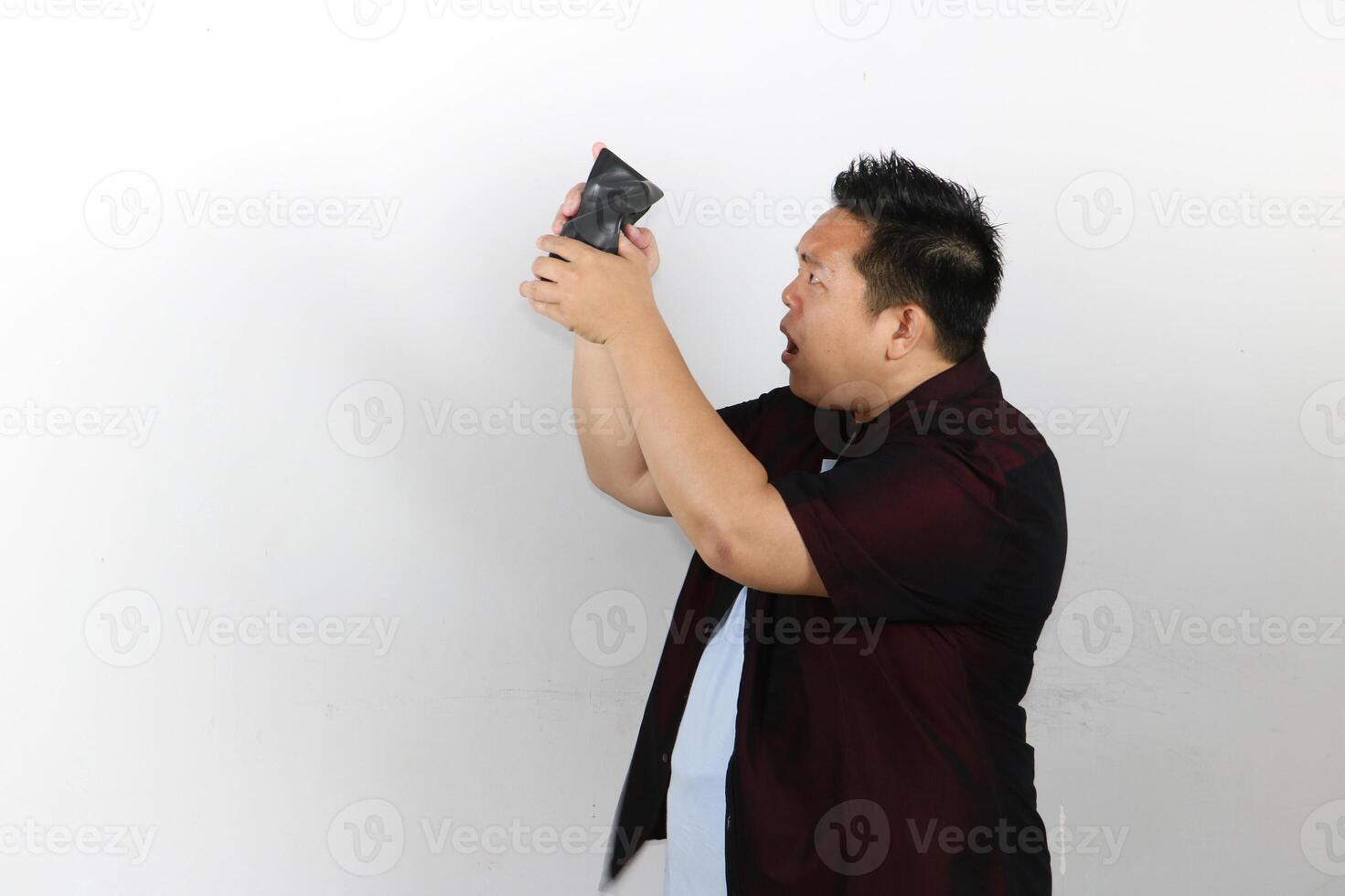 Sad Asian man looking in an empty wallet photo