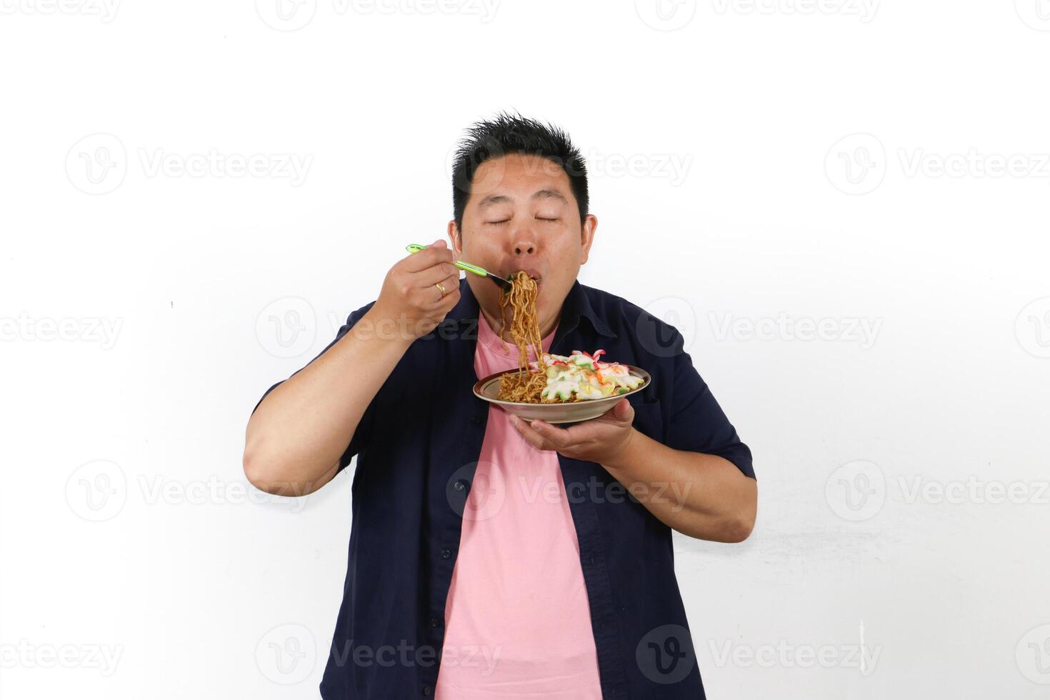 Hungry Man enjoying Delicious Indonesian Fried noodles with satisfied expression photo