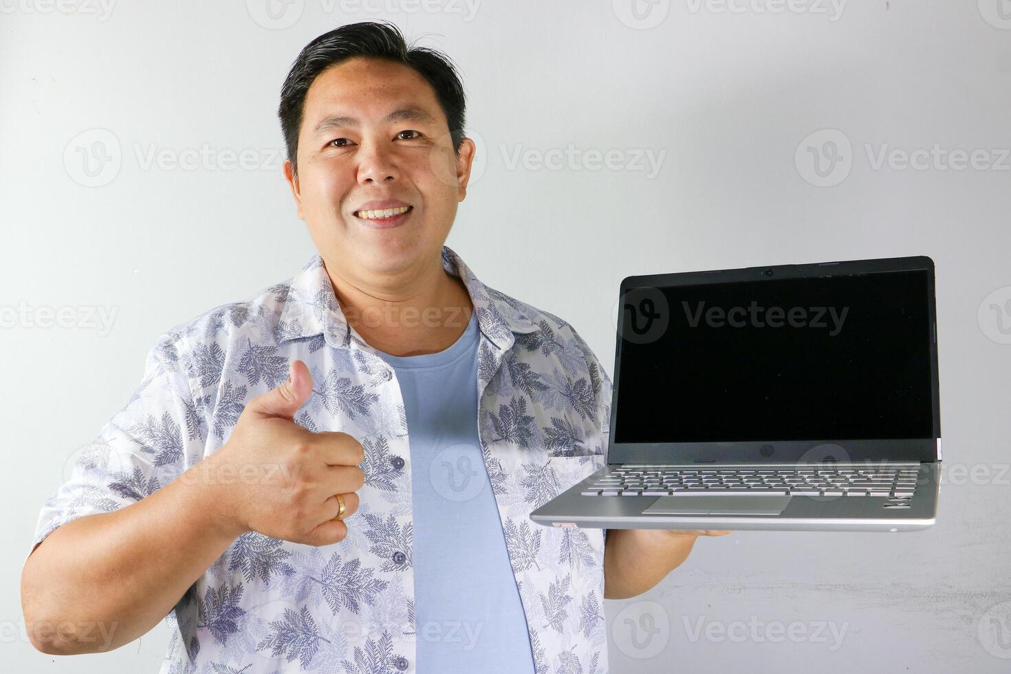 Happy Man Recommending Laptop with thumbs up photo