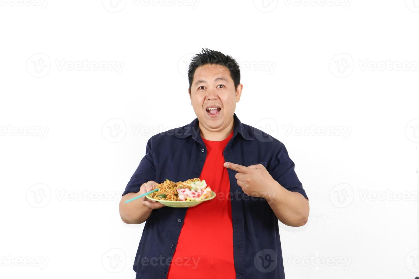 Happy Asian man pointing at his plate of Indonesian Fried Noodles photo