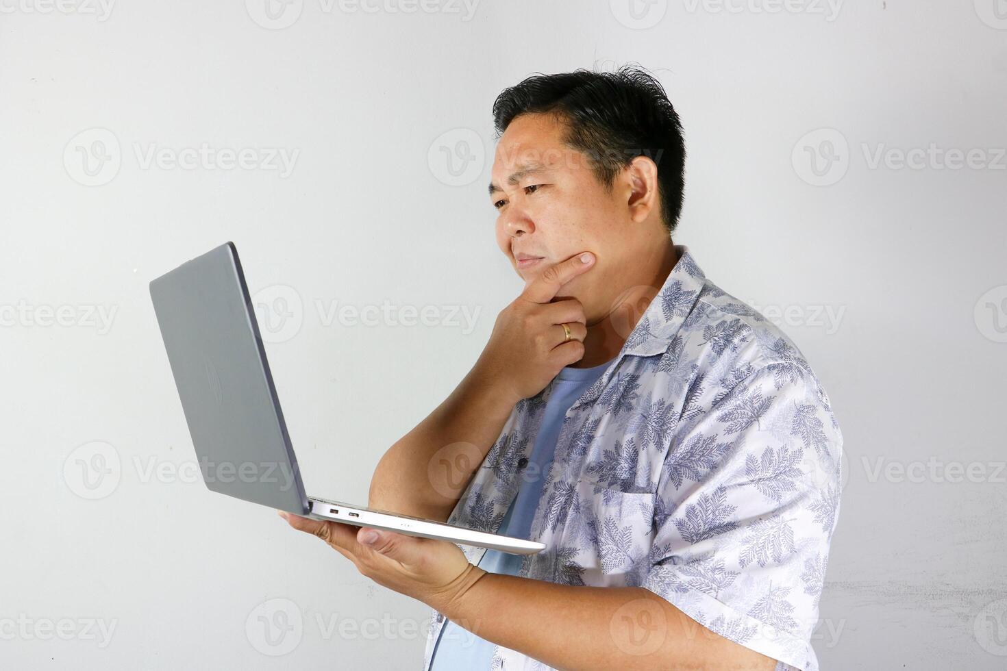 Man Thinking on Laptop, hand holding chin photo