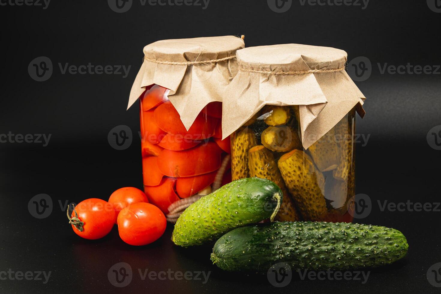 Homemade canned pickles and preserved vegetables on black background photo