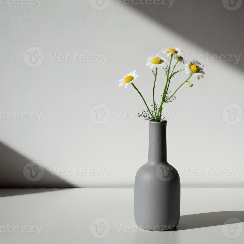 A single white daisy in modern dark gray ceramic vase, illuminated by moody lighting, creating an elegant and artistic still life composition photo