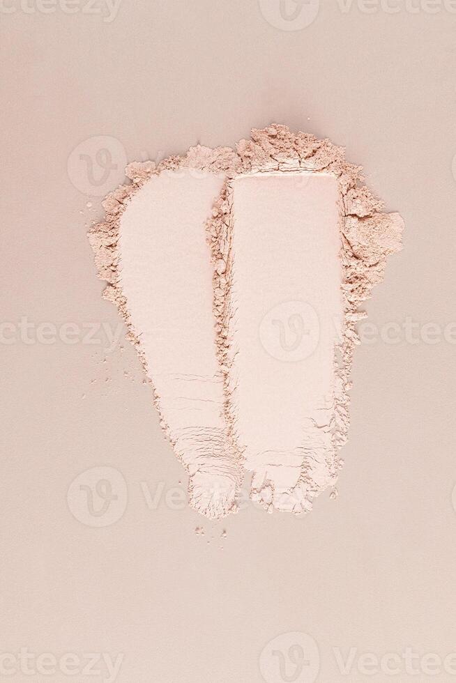 Two chic cosmetic samples of loose powder in a natural tone on a beige background. vertical top view. cosmetic texture. Layout for product advertising photo