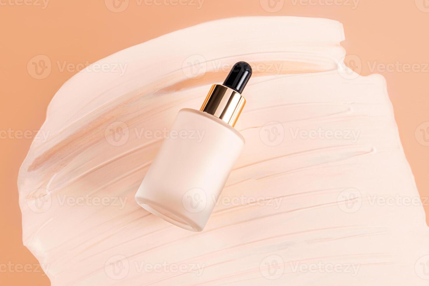 A cosmetic glass bottle with a dropper with a natural tone liquid foundation rests on a chic sample of the texture of powder. top view. decorative photo