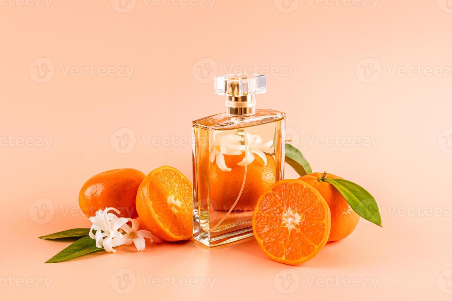 A chic bottle with a crystal cap with eau de parfum or perfume stands among ripe tangerines. feminine and masculine essence. Product Presentation photo