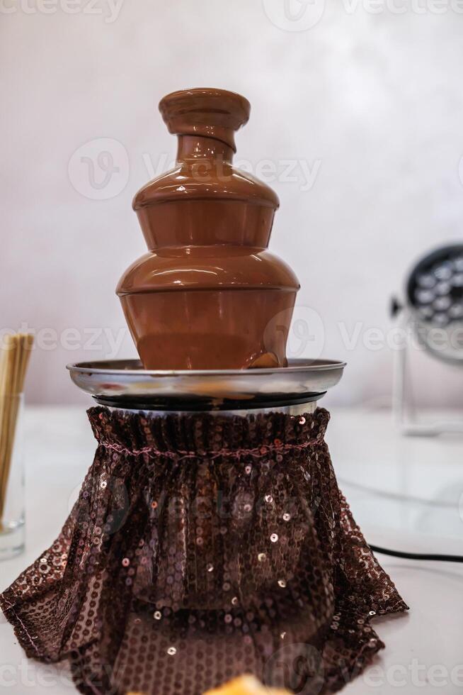 A chocolate fountain with a chocolate cake on top photo