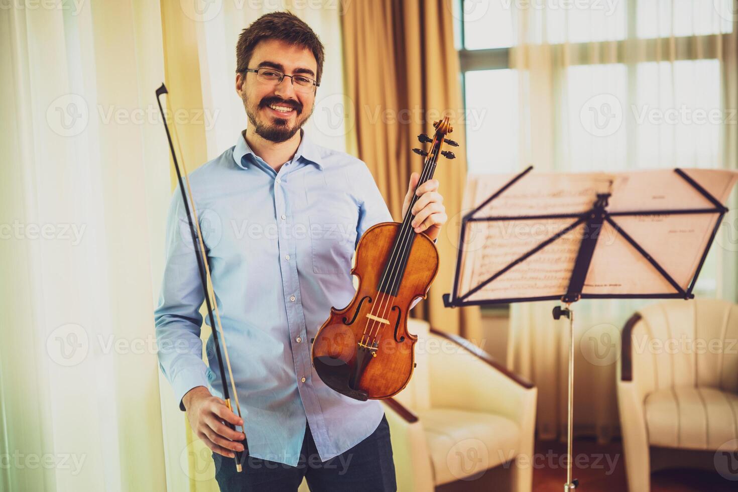 Portrait of man with violin at home. photo