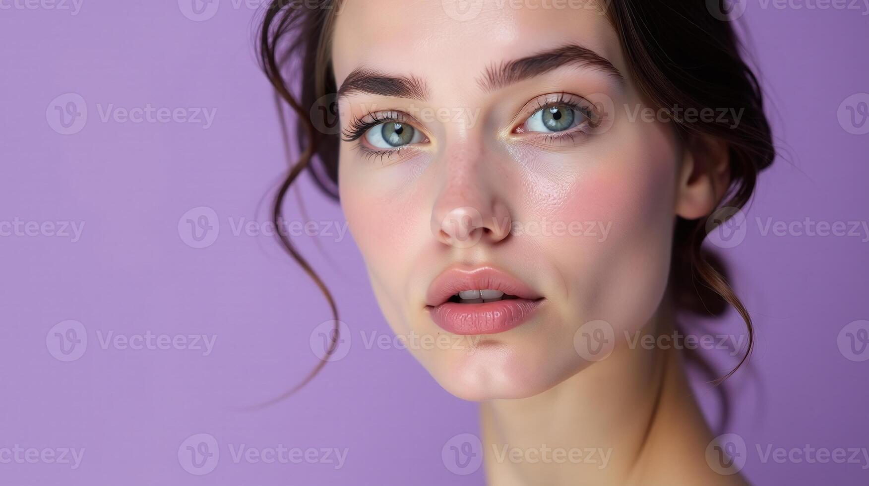 The image displays a close-up portrait of a person's face with a soft, neutral background. photo
