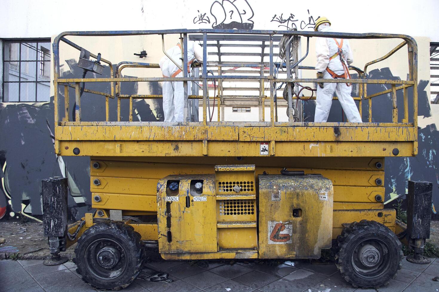 A yellow construction vehicle parked in front of a building photo