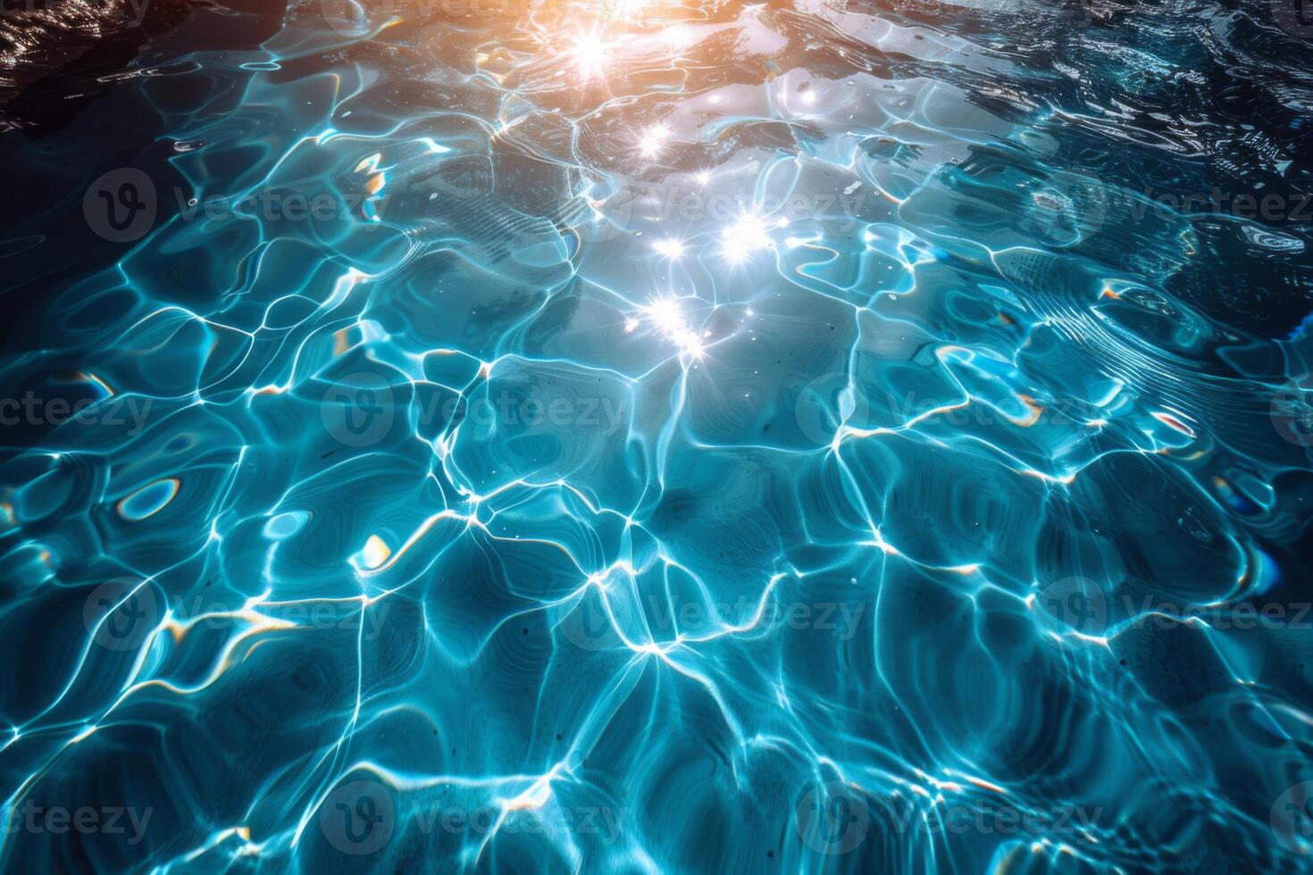 Light reflects off a swimming pool's surface, creating rippling patterns of aqua and turquoise hues. A serene, refreshing summer vibe captured perfectly photo