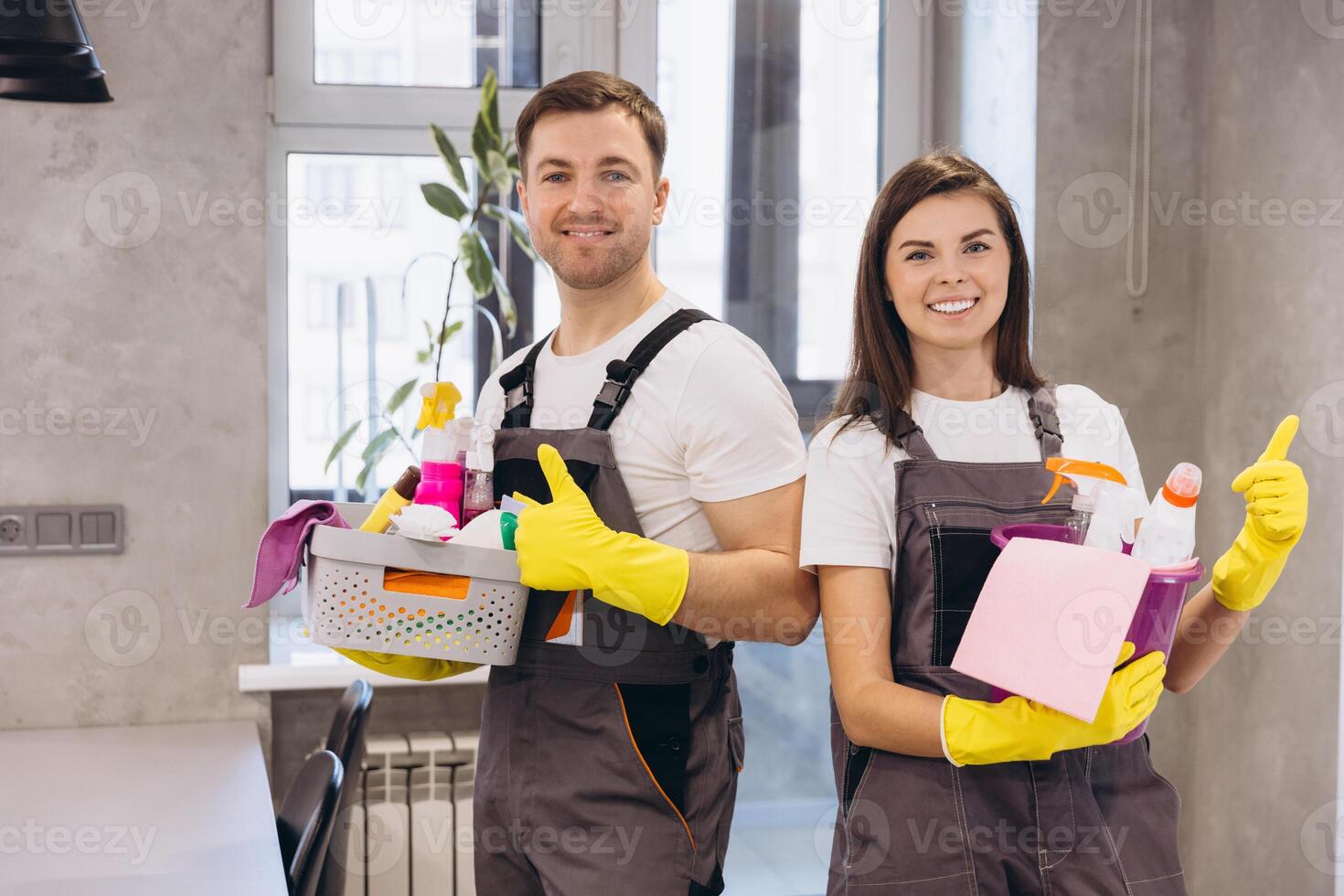 Cleaning company staff holding cleaning products showing thumbs up photo
