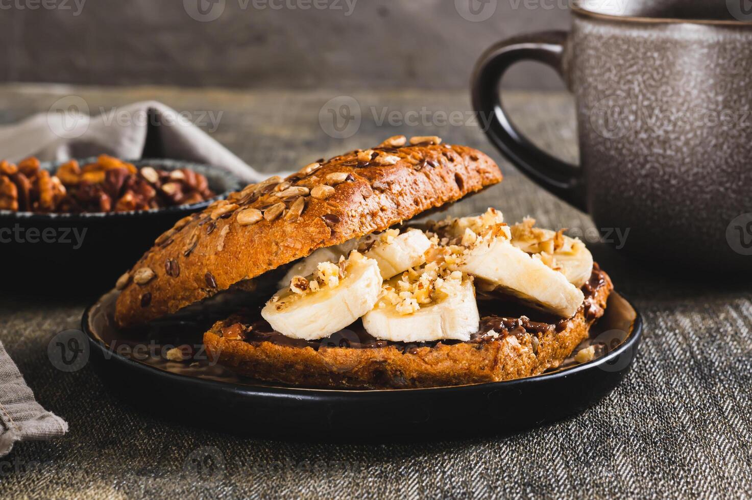 Close up of toast rye bread with chocolate and banana on a plate on the table photo