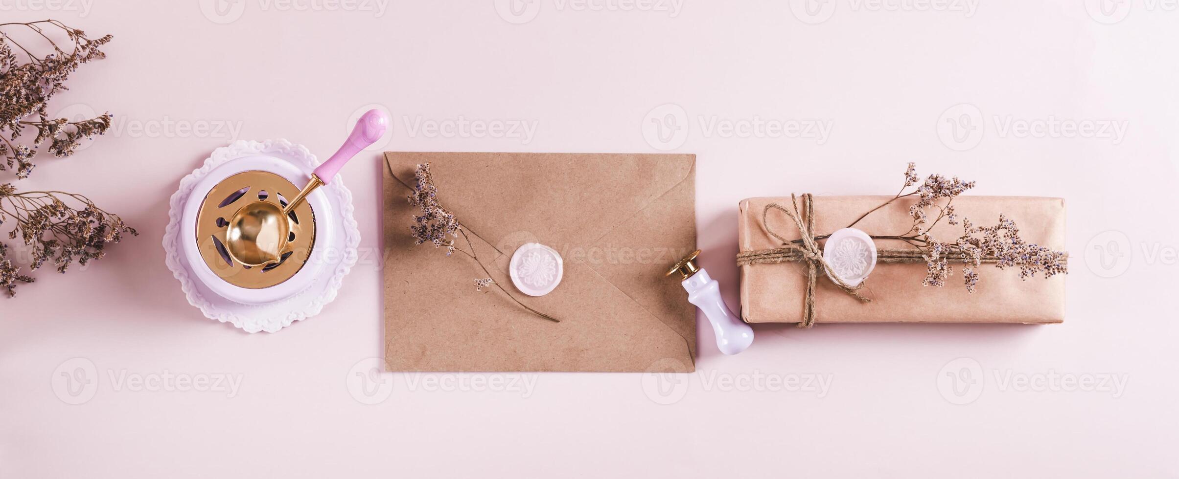Craft envelope with wax seal and crafting items on pink top view web banner photo