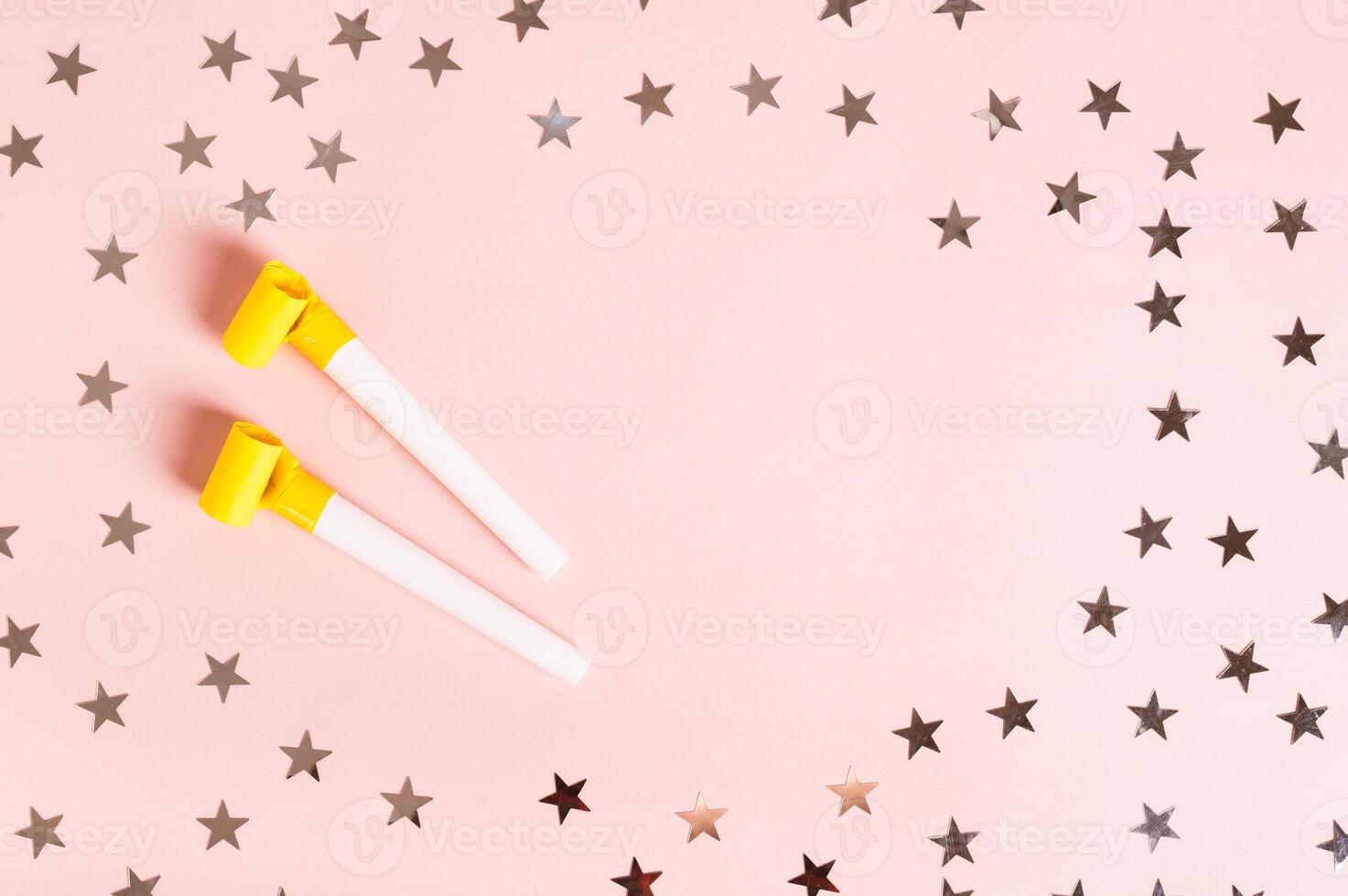 Happy April Fools' Day whistles and stars on pink top view copy space photo
