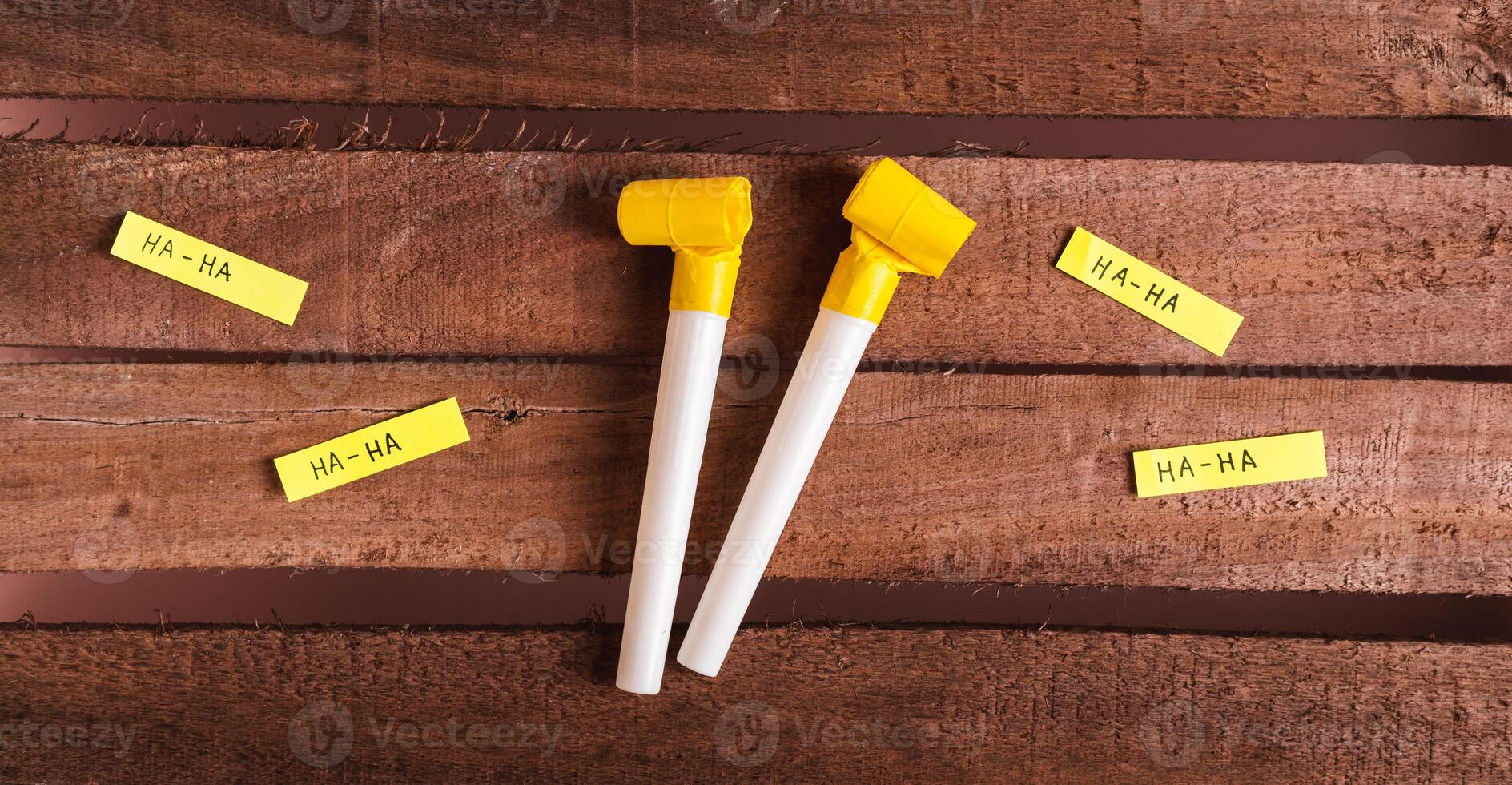 Happy April Fools Day, whistles and funny notes on wooden background top view web banner photo