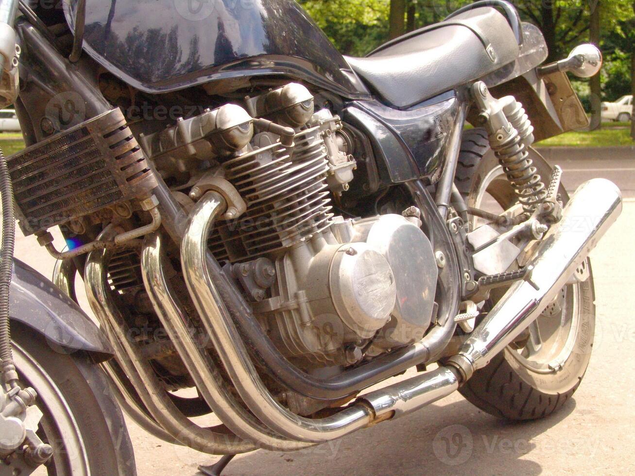 Close up of a Classic Motorcycle Engine with Chrome Exhaust Pipes photo