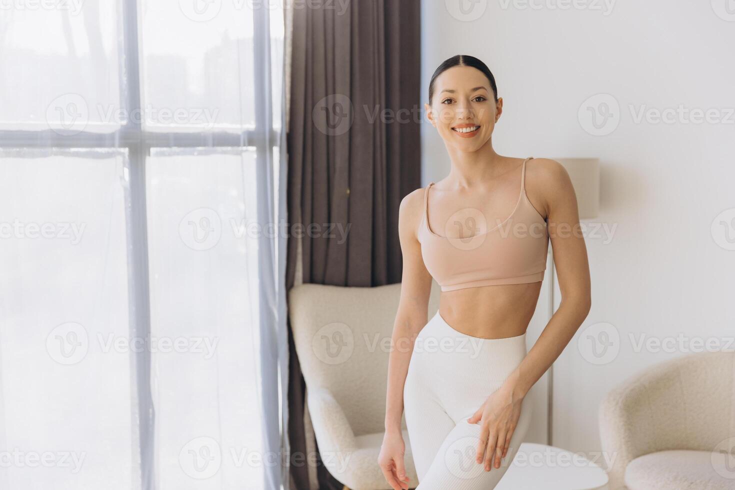 Young woman practicing yoga at home smiling and relaxing photo