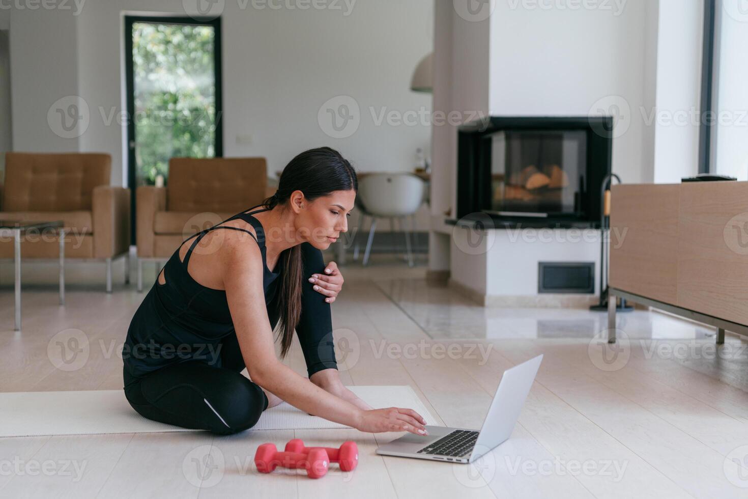Young Beautiful Female Exercising, Stretching and Practising Yoga with Trainer via Call Conference in Bright Sunny House. Healthy Lifestyle, Wellbeing and Mindfulness Concept. photo