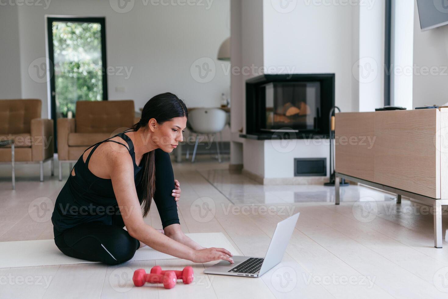 Young Beautiful Female Exercising, Stretching and Practising Yoga with Trainer via Call Conference in Bright Sunny House. Healthy Lifestyle, Wellbeing and Mindfulness Concept. photo