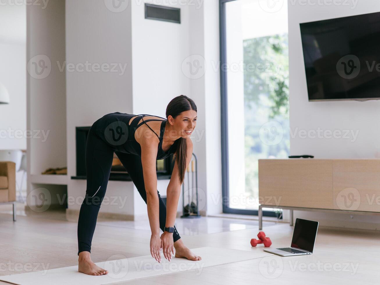 Young Beautiful Female Exercising, Stretching and Practising Yoga with Trainer via Call Conference in Bright Sunny House. Healthy Lifestyle, Wellbeing and Mindfulness Concept photo