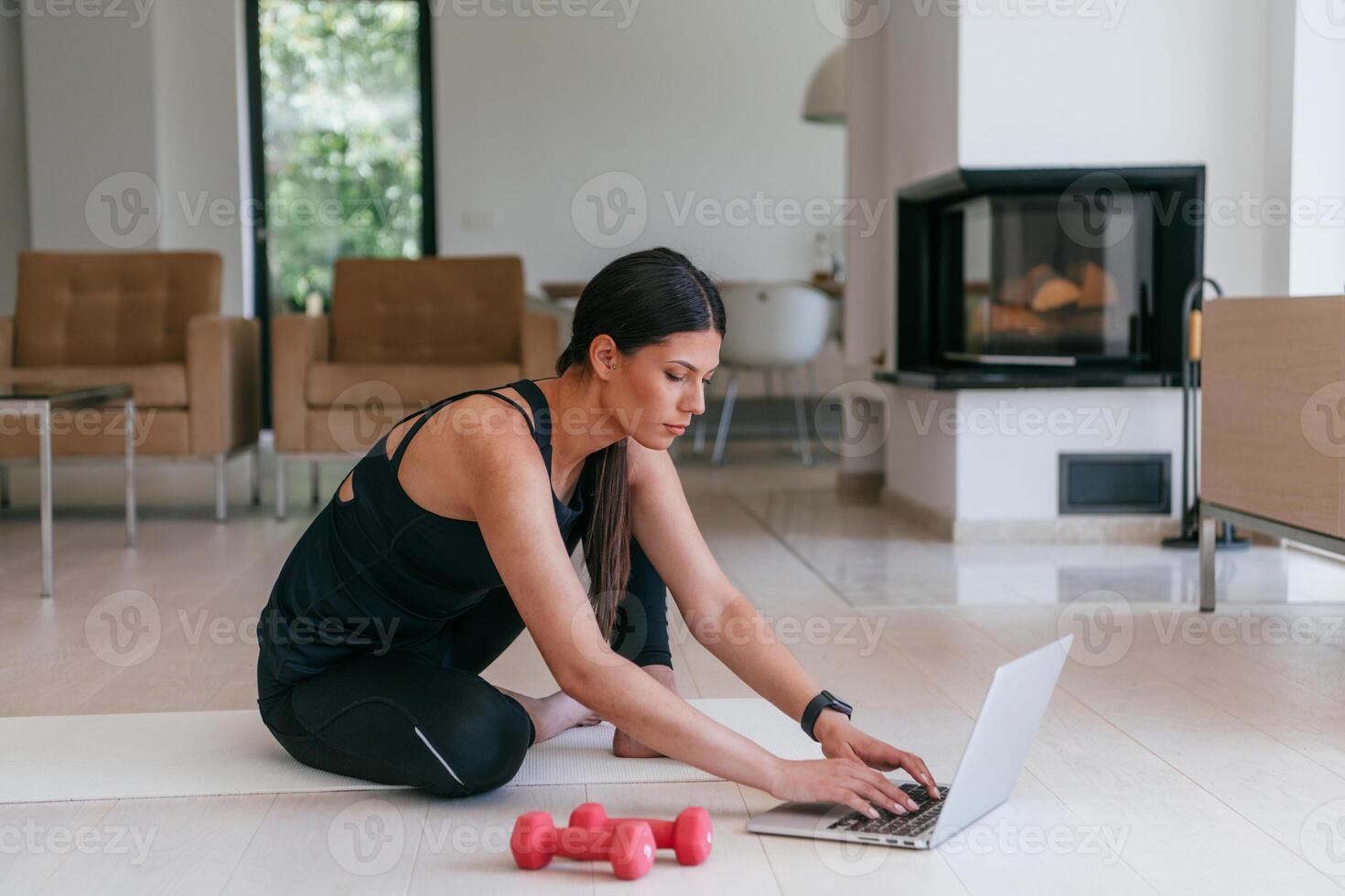Young Beautiful Female Exercising, Stretching and Practising Yoga with Trainer via Call Conference in Bright Sunny House. Healthy Lifestyle, Wellbeing and Mindfulness Concept. photo
