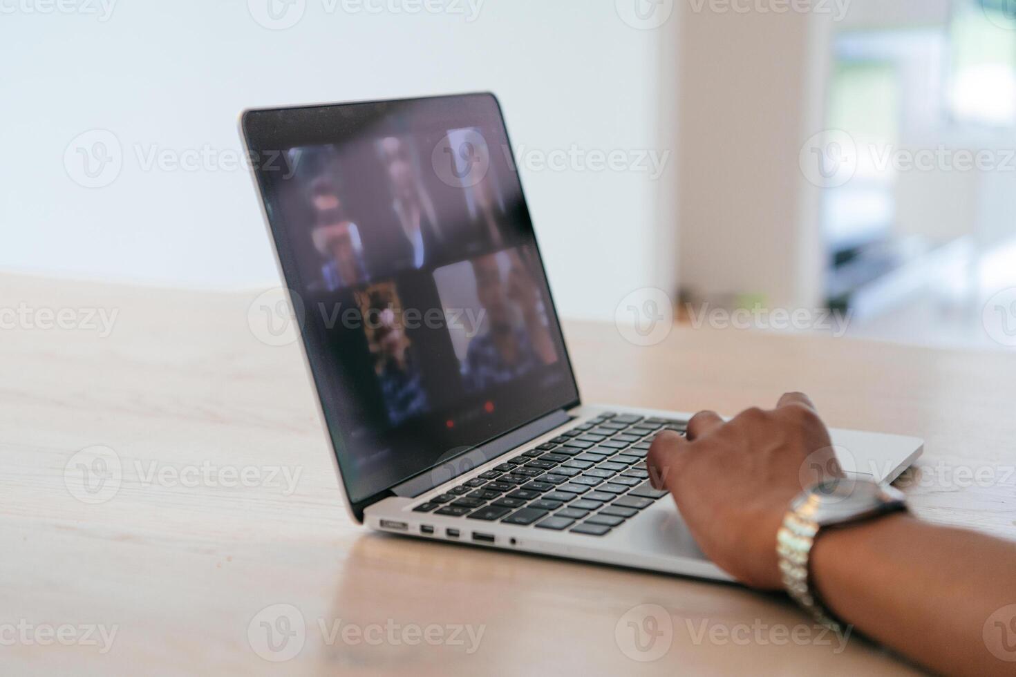 Photo of a laptop with modern headphones on a wooden table in a house with a modern interior.