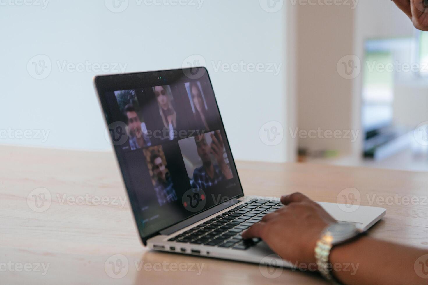 Photo of a laptop with modern headphones on a wooden table in a house with a modern interior.