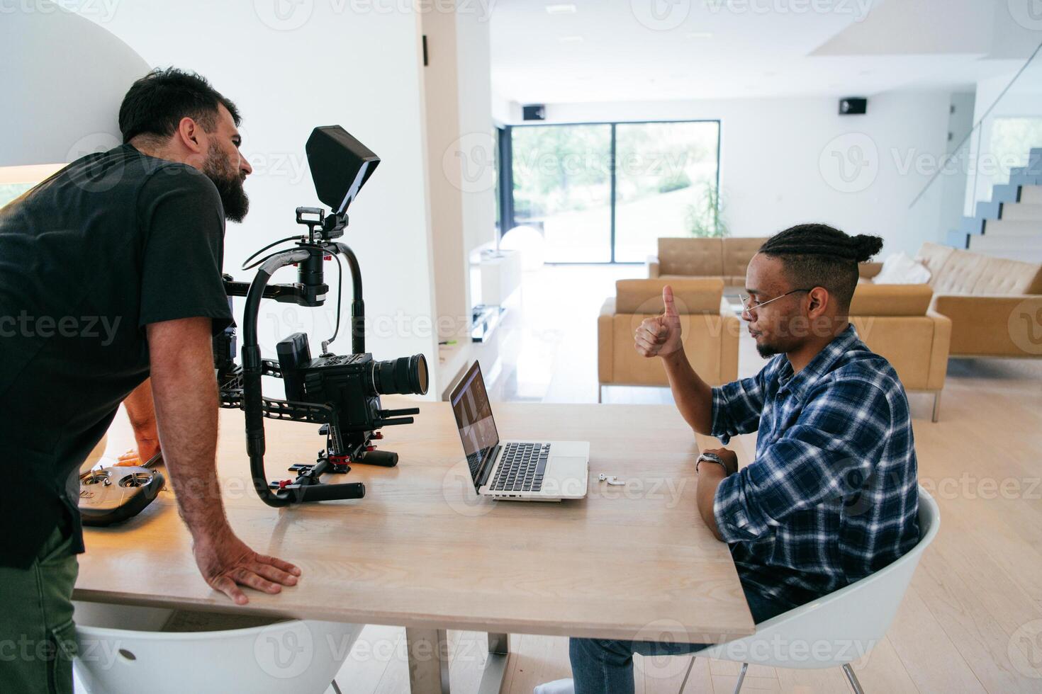A cameraman talking with an African American man as they preparing to shoot a commercial . High quality photo