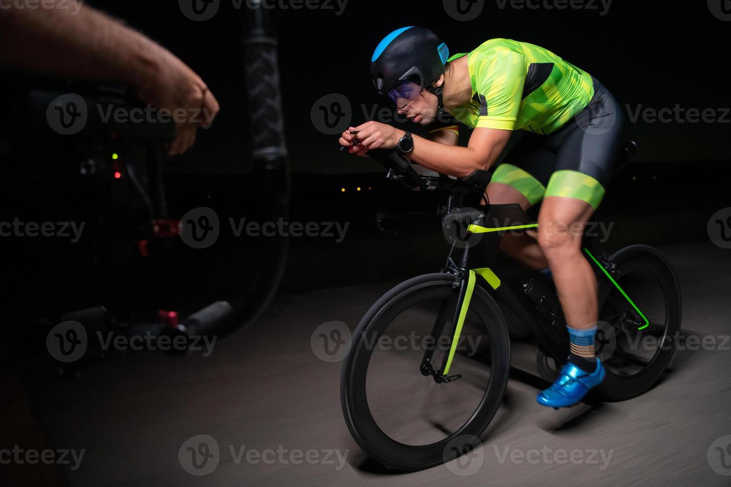 A videographer recording a triathlete riding his bike preparing for an upcoming marathon.Athlete's physical endurance and the dedication required to succeed in the sport. photo