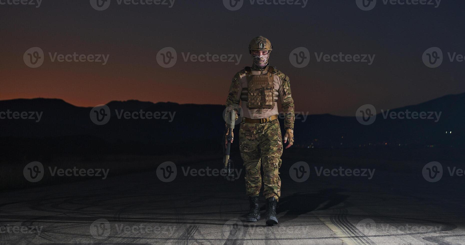 A professional soldier in full military gear striding through the dark night as he embarks on a perilous military mission photo