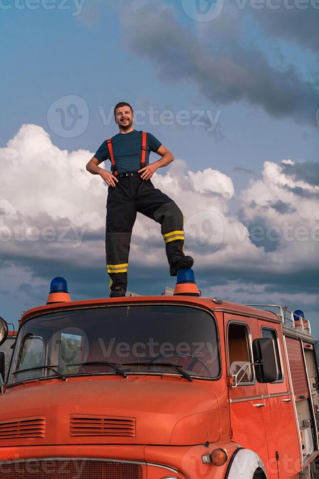 The firefighter standing confidently on the fire truck, ready to respond to any emergency. photo