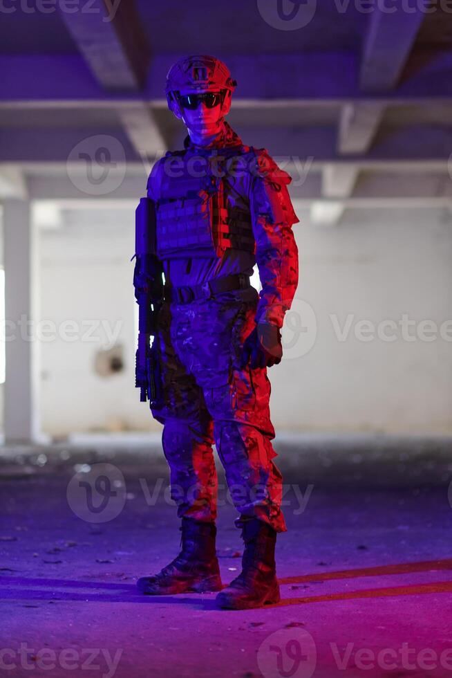 A professional soldier undertakes a perilous mission in an abandoned building illuminated by neon blue and purple lights photo