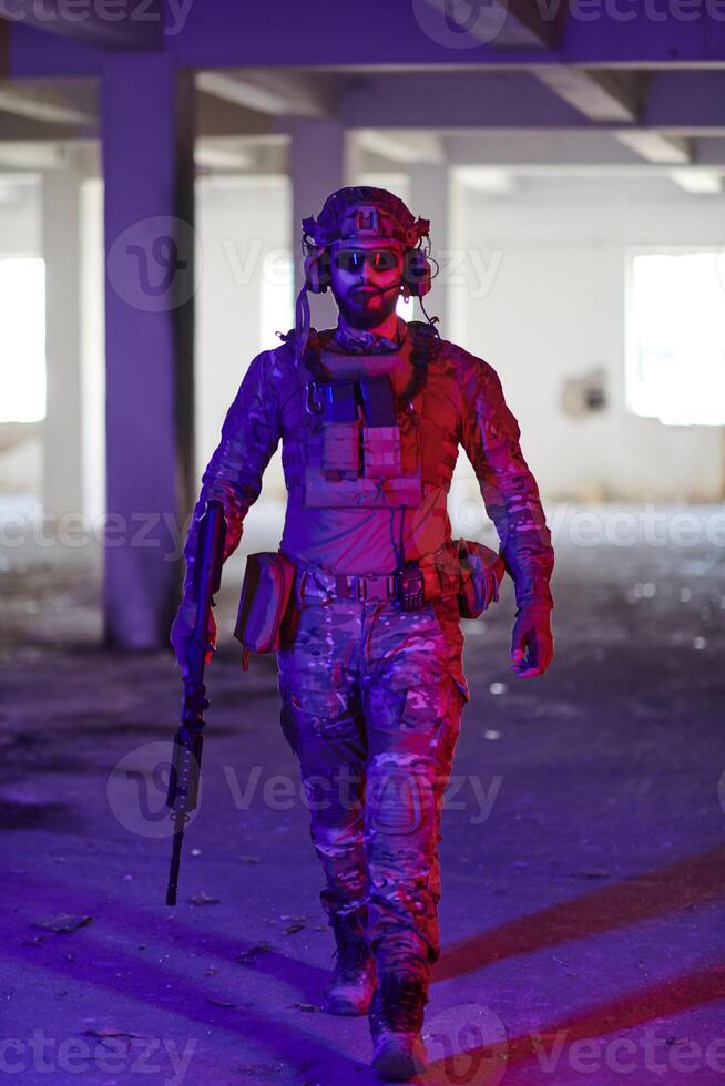 A professional soldier undertakes a perilous mission in an abandoned building illuminated by neon blue and purple lights photo