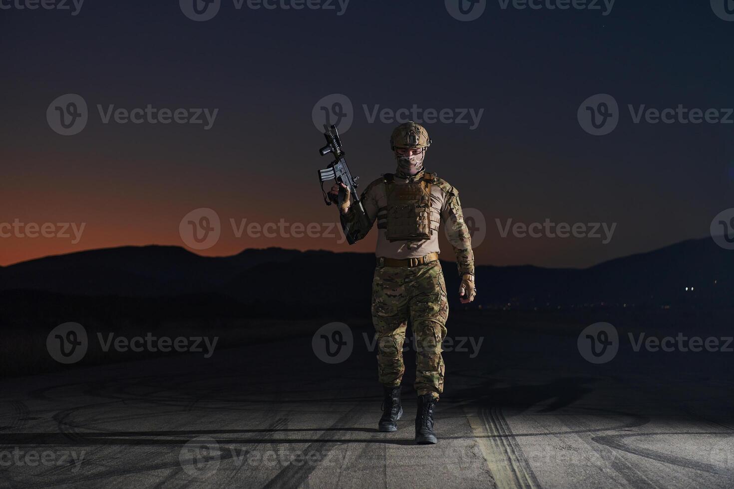 A professional soldier in full military gear striding through the dark night as he embarks on a perilous military mission photo