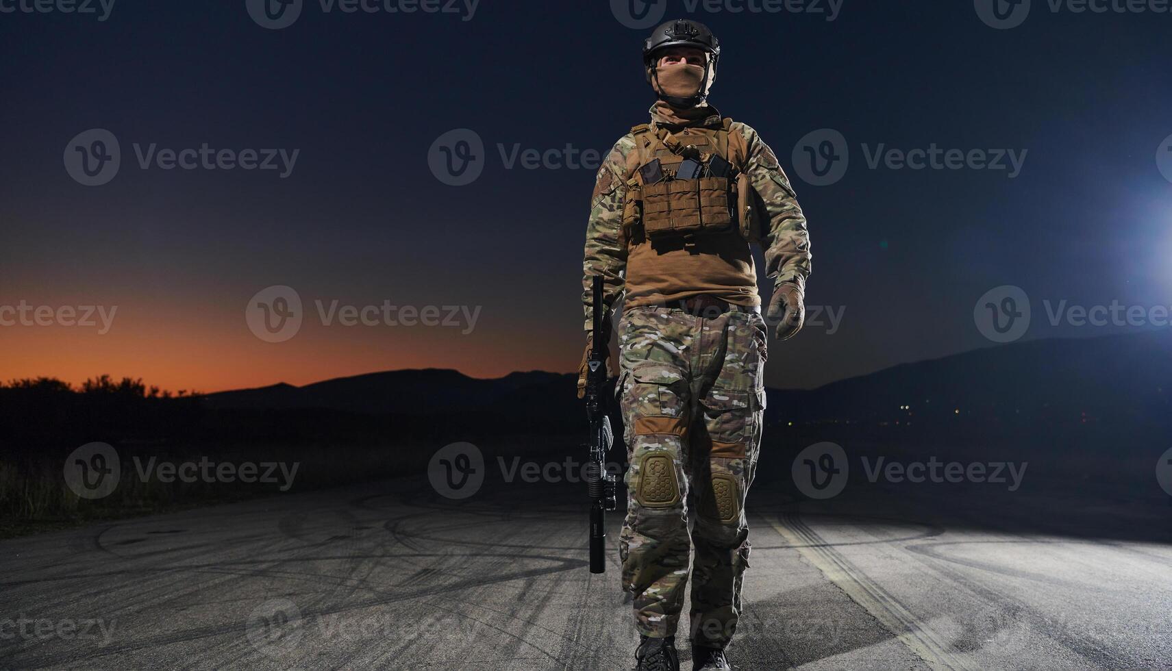 A professional soldier in full military gear striding through the dark night as he embarks on a perilous military mission photo