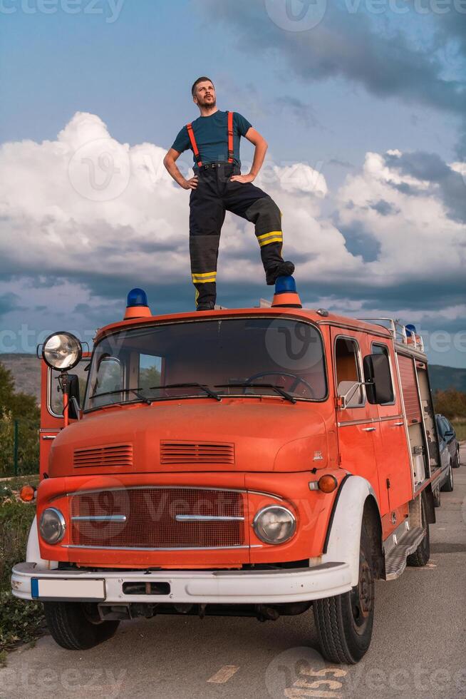 The firefighter standing confidently on the fire truck, ready to respond to any emergency. photo