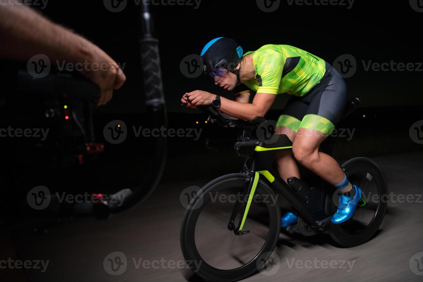 A videographer recording a triathlete riding his bike preparing for an upcoming marathon.Athlete's physical endurance and the dedication required to succeed in the sport. photo