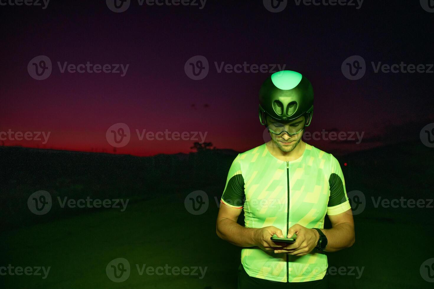 A triathlete using a smartphone while taking a break from a hard night's cycling training photo