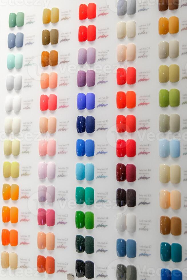 A row of nail polish colors are displayed on a wall photo