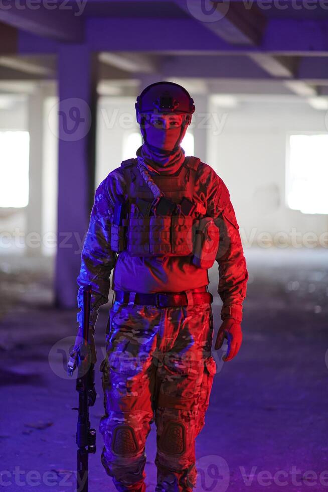 A professional soldier undertakes a perilous mission in an abandoned building illuminated by neon blue and purple lights photo