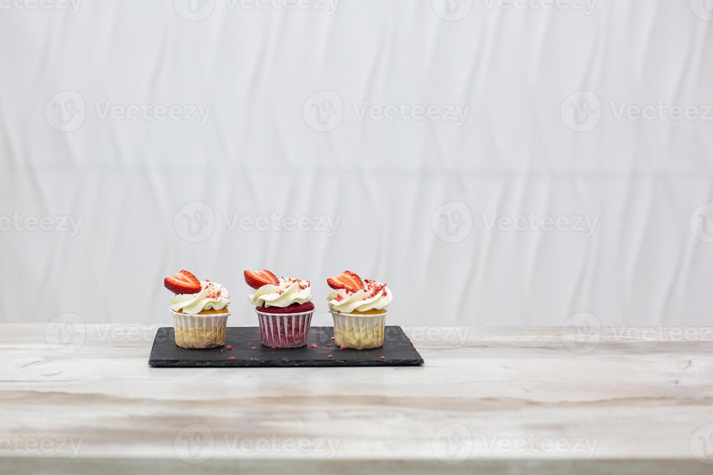 Image of batch of homemade, strawberry cupcakes on white background photo