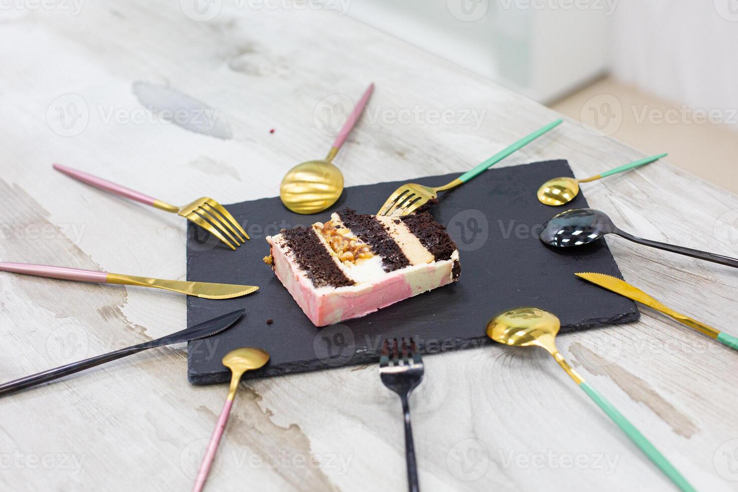 a piece of cake on a plate and a lot of spoons around photo