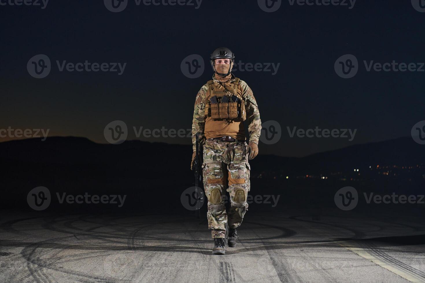 A professional soldier in full military gear striding through the dark night as he embarks on a perilous military mission photo