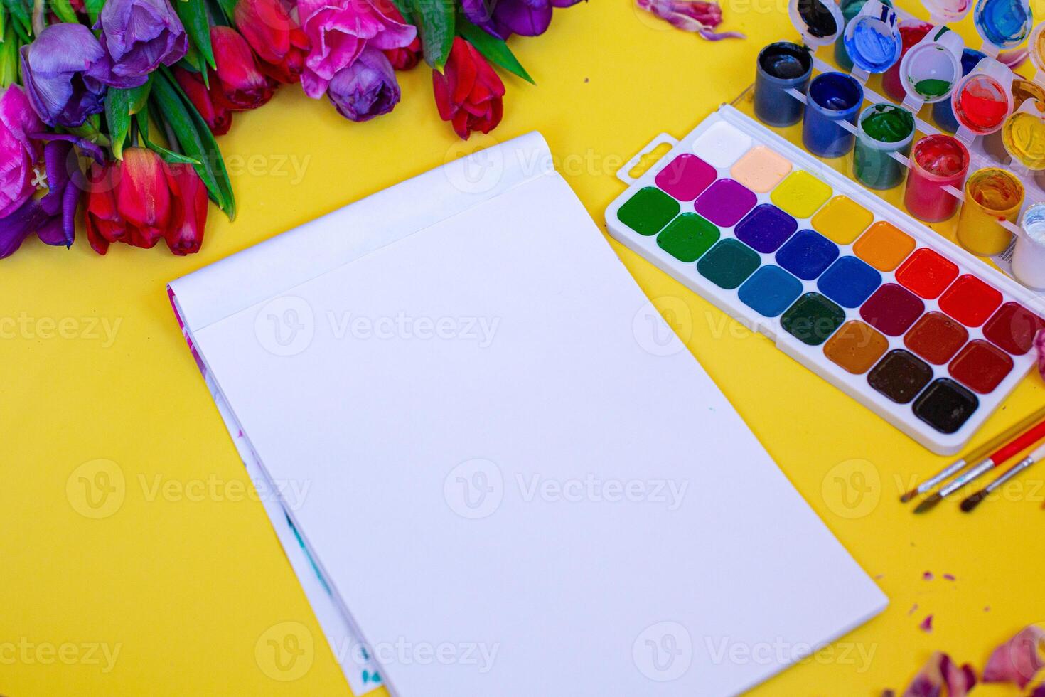 layout with aquarelle palette, paint brushes on yellow background photo
